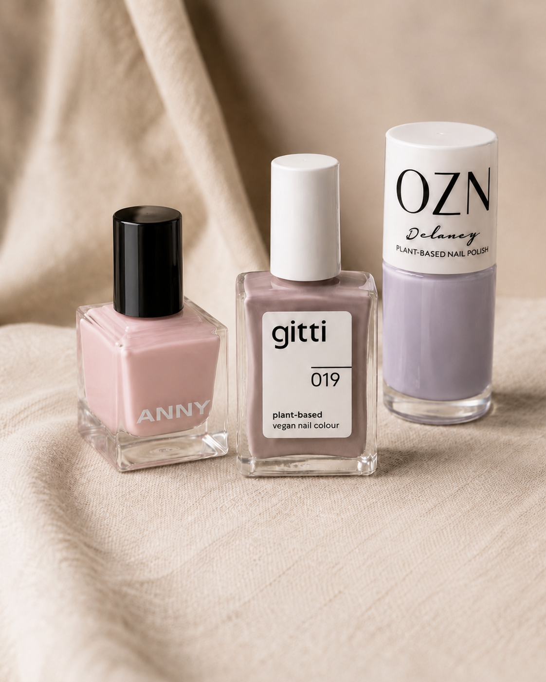 Produktfotografie von 3 Nagellacken auf einem beigen Tuch