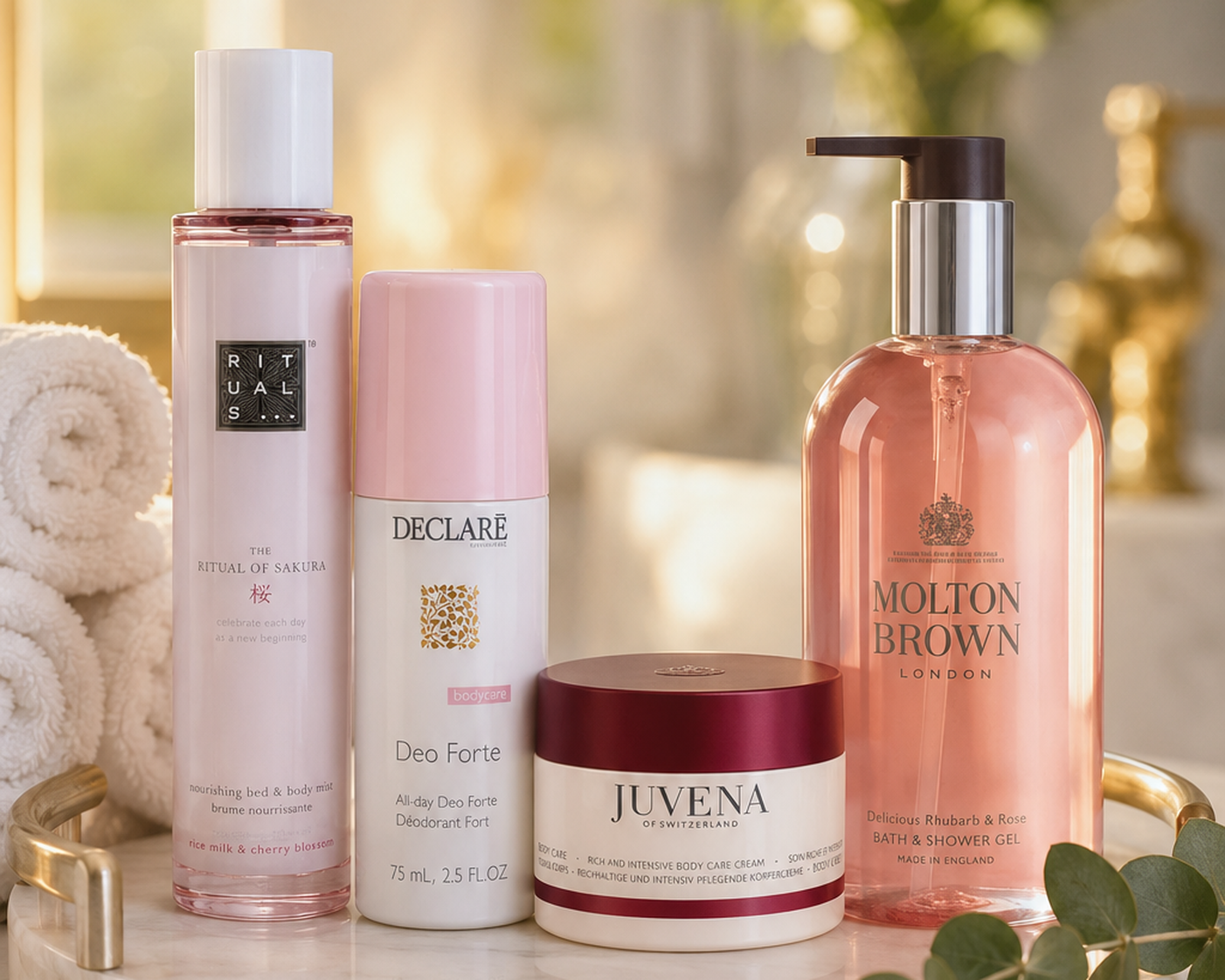 Vier Pflegeprodukte von Rituals, Declaré, Juvena und Molton Brown nebeneinander arrangiert auf einem Marmortablett.